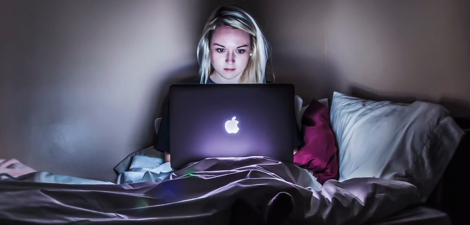 woman with laptop on bed